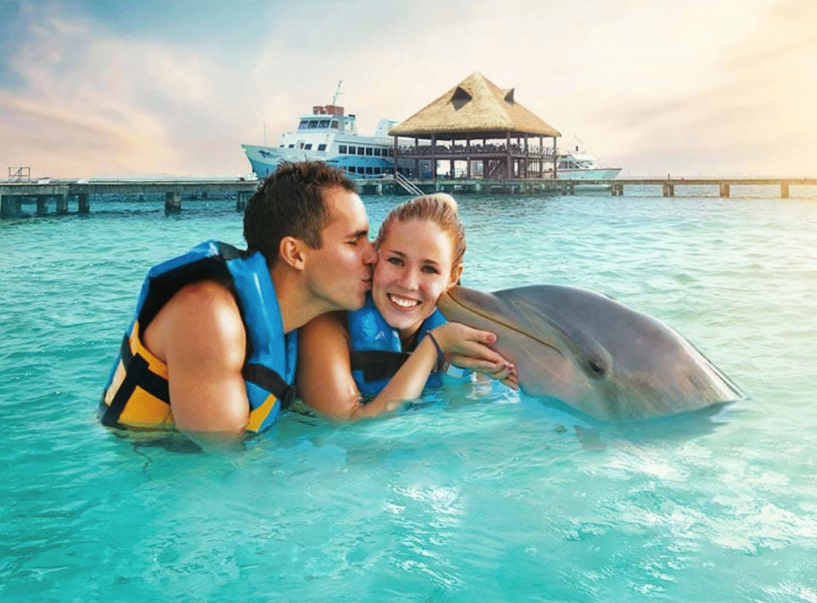 Two people swimming with dolphins in Isla Mujeres