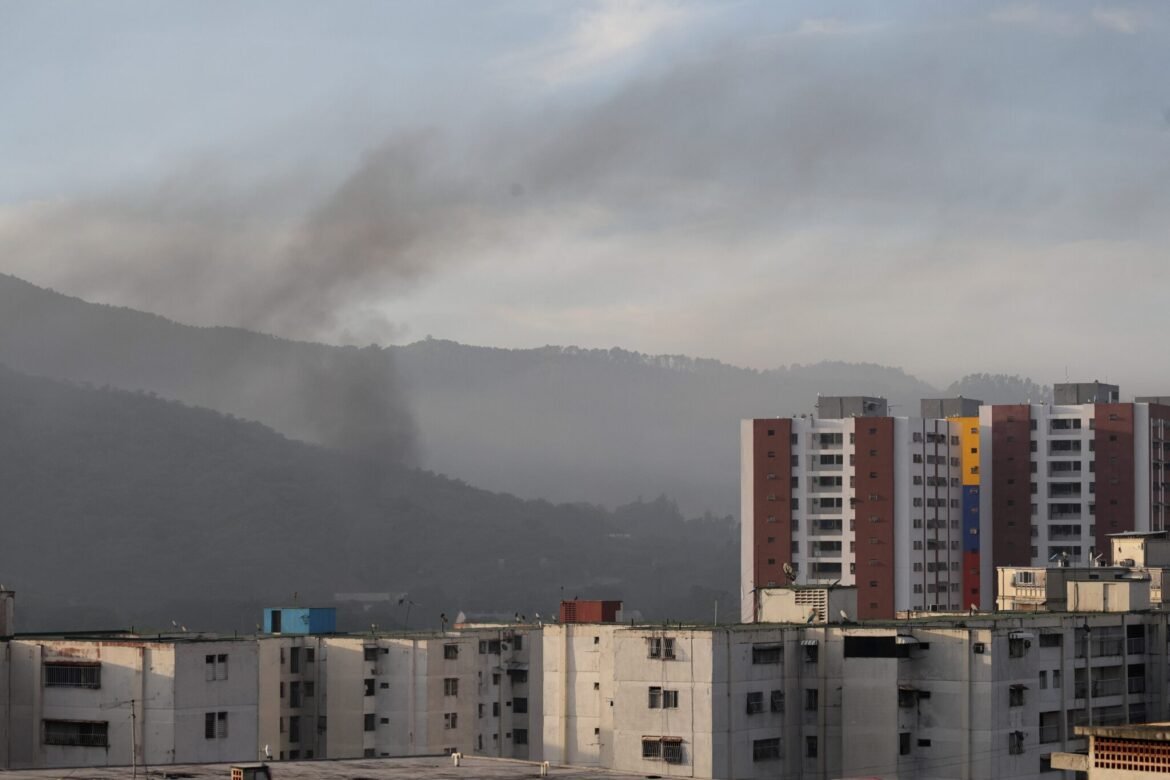Smoke is seen over buildings after explosions and low-flying aircraft were heard on Jan. 3, 2026 in Caracas, Venezuela. According to some reports, explosions were heard in Caracas and other cities near airports and military bases around 2 a.m. (Photo by Jesus Vargas/Getty Images)