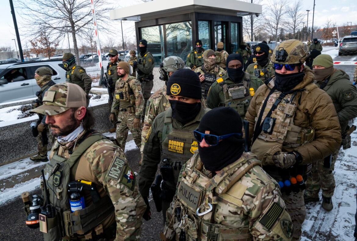 Federal agents stage at a front gate as Reps. Ilhan Omar, Kelly Morrison and Rep. Angie Craig, all Minnesota Democrats, attempt to enter the regional Immigration and Customs Enforcement headquarters at the Bishop Henry Whipple Federal Building in Minneapolis on Jan. 10, 2026. The House members were briefly allowed access to the facility where the Department of Homeland Security has been headquartering operations in the state. (Photo by Stephen Maturen/Getty Images)