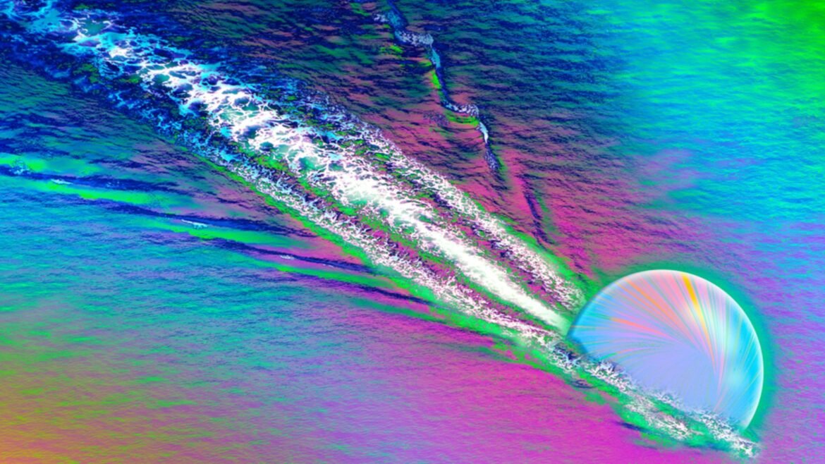 A colorful image shows a opalescent sphere carving a streak through a rainbow colored surface, kicking up white streaks behind it
