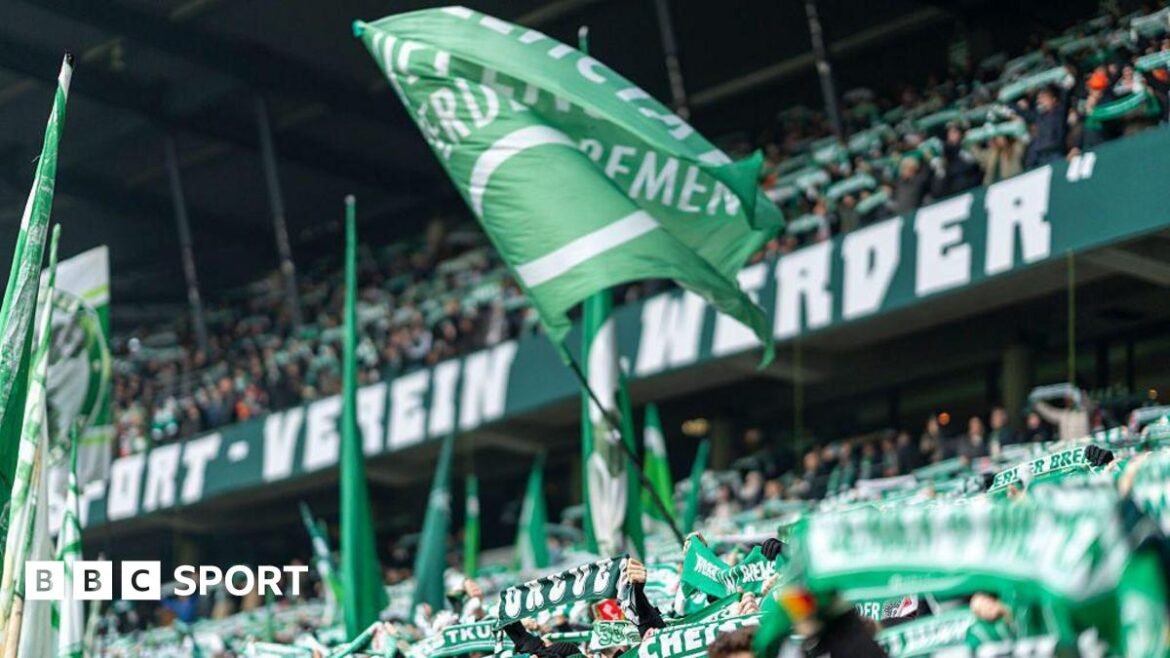 Green Werder Bremen flags are waved by supporters in the club's ground