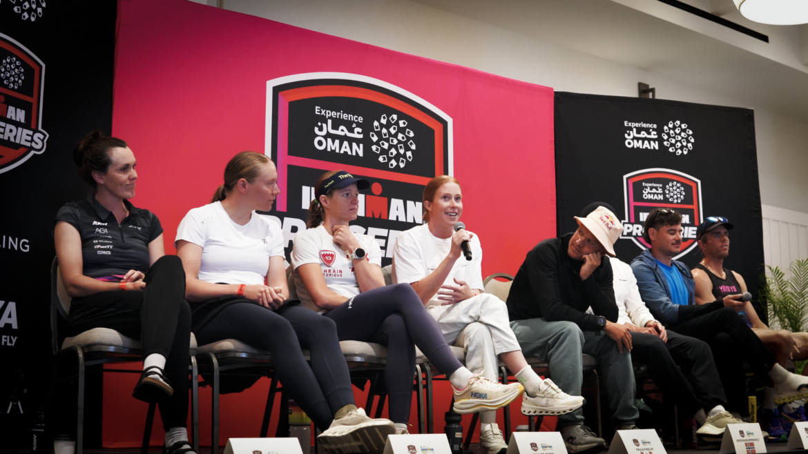 eight pro triathletes sit on Ironman branded stage as part of press conference for Ironman 70.3 Oceanside