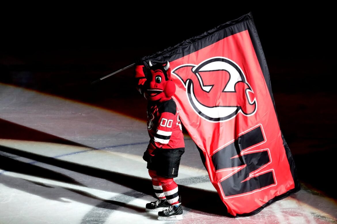 NJ Devil, the New Jersey Devils mascot, carries a flag after the Devils defeated the Carolina Hurricanes 3-2 during an NHL hockey game, Sunday, Feb. 10, 2019, in Newark, N.J. (AP Photo/Julio Cortez)