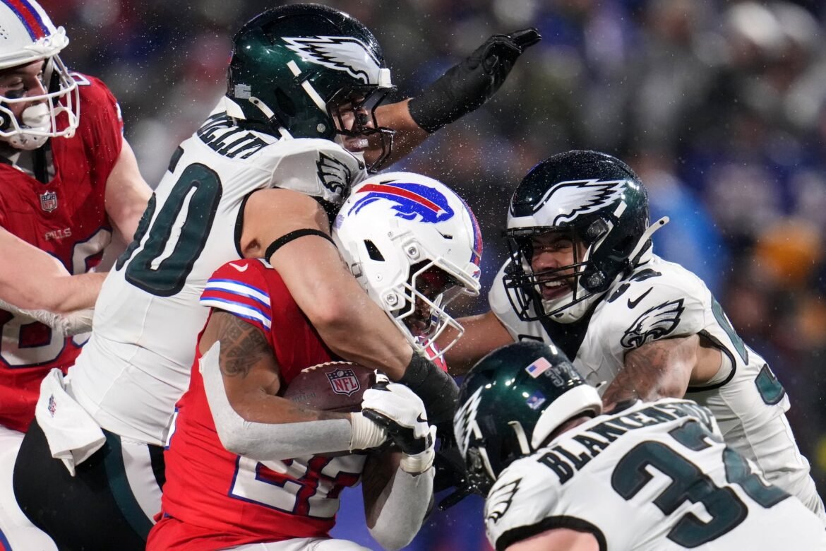Buffalo Bills' Ray Davis (22) is tackled by Philadelphia Eagles' Jaelan Phillips (50), Zack Baun (53) and Reed Blankenship (32) during the second half of an NFL football game, Sunday, Dec. 28, 2025, in Buffalo, N.Y. (AP Photo/Gene J. Puskar)