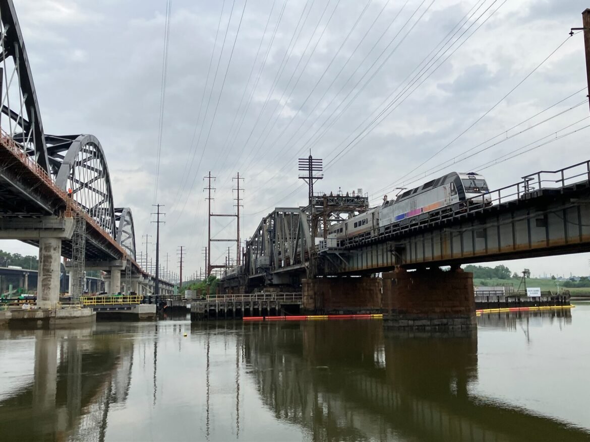 An NJ Transit train crosses the 116-year-old Portal Bridge over the Hackensack River in Kearny. NJ Transit trains used the new bridge, seen on the left, two days early after a problem closed the old span. Larry Higgs| NJ Advance Media for NJ.com