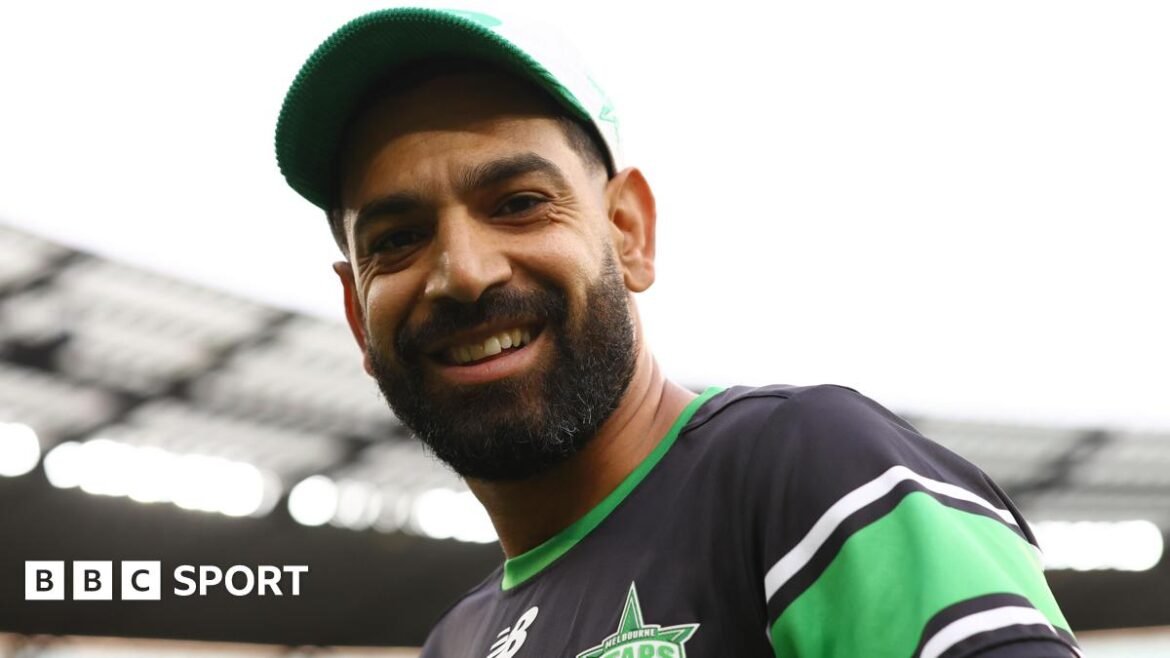 Haris Rauf wearing a cap and smiling at the camera