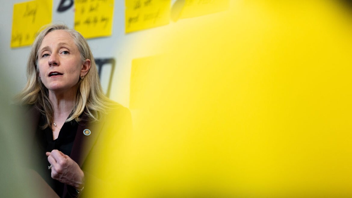 Abigail Spanberger framed by an out-of-focus yellow sign in the foreground.