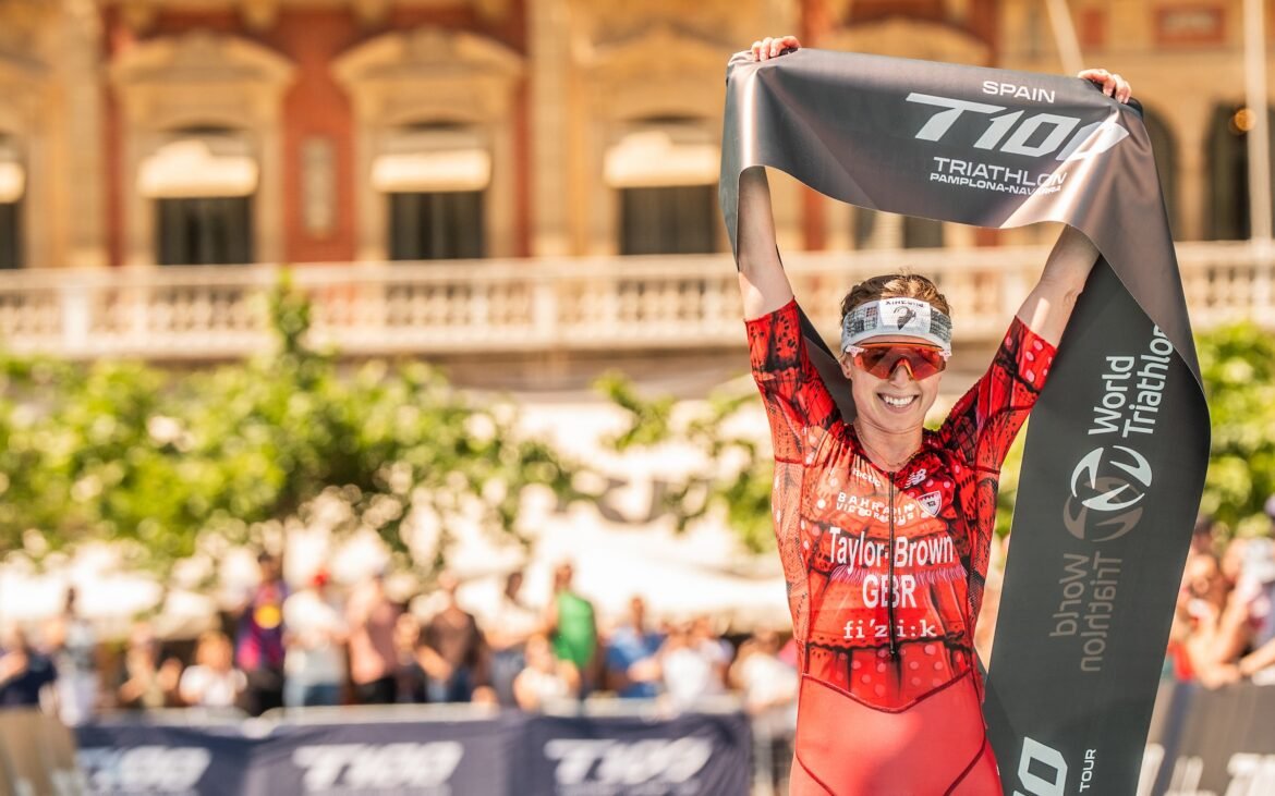 Georgia Taylor-Brown celebrates with finishing banner at the 2026 T100 Span race.