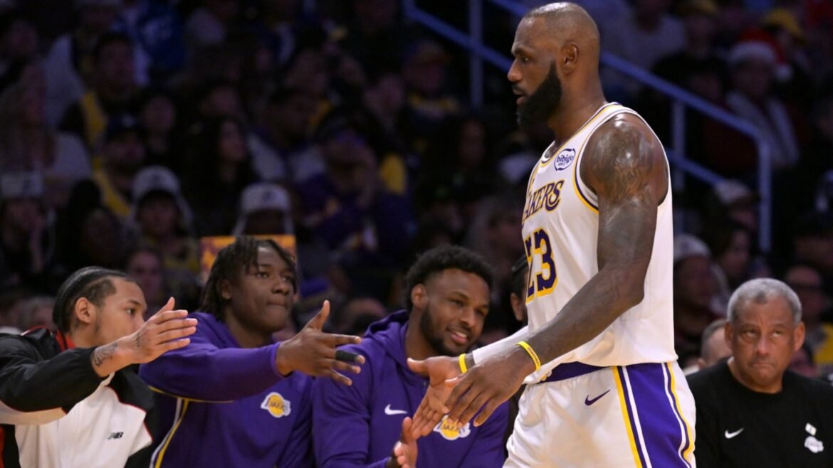 Los Angeles Lakers forward LeBron James is greeted at the bench after he leaves the court during the second half of an NBA basketball game against the Houston Rockets, Thursday, Dec. 25, 2025, in Los Angeles. )