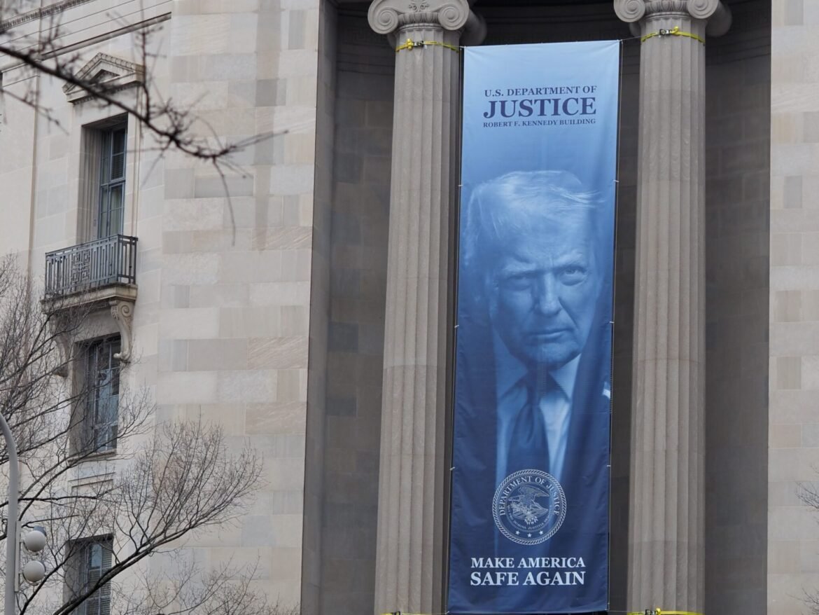 A banner showing President Donald Trump hangs from the U.S. Department of Justice on Feb. 20, 2026. (Photo by Shauneen Miranda/States Newsroom)