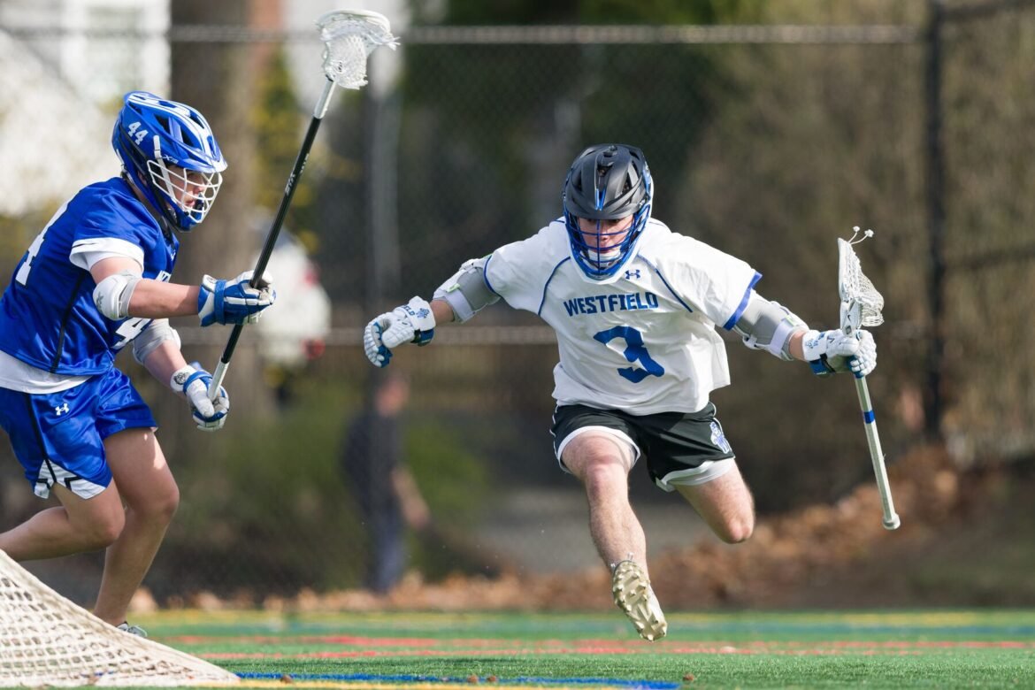 Koby Waldman of Westfield (3) gallops past Adam Cherkin of Montclair in Friday's high school boys lacrosse matchup in Montclair. The Blue Devils whipped the Mounties, 17-4.  04/10/2026