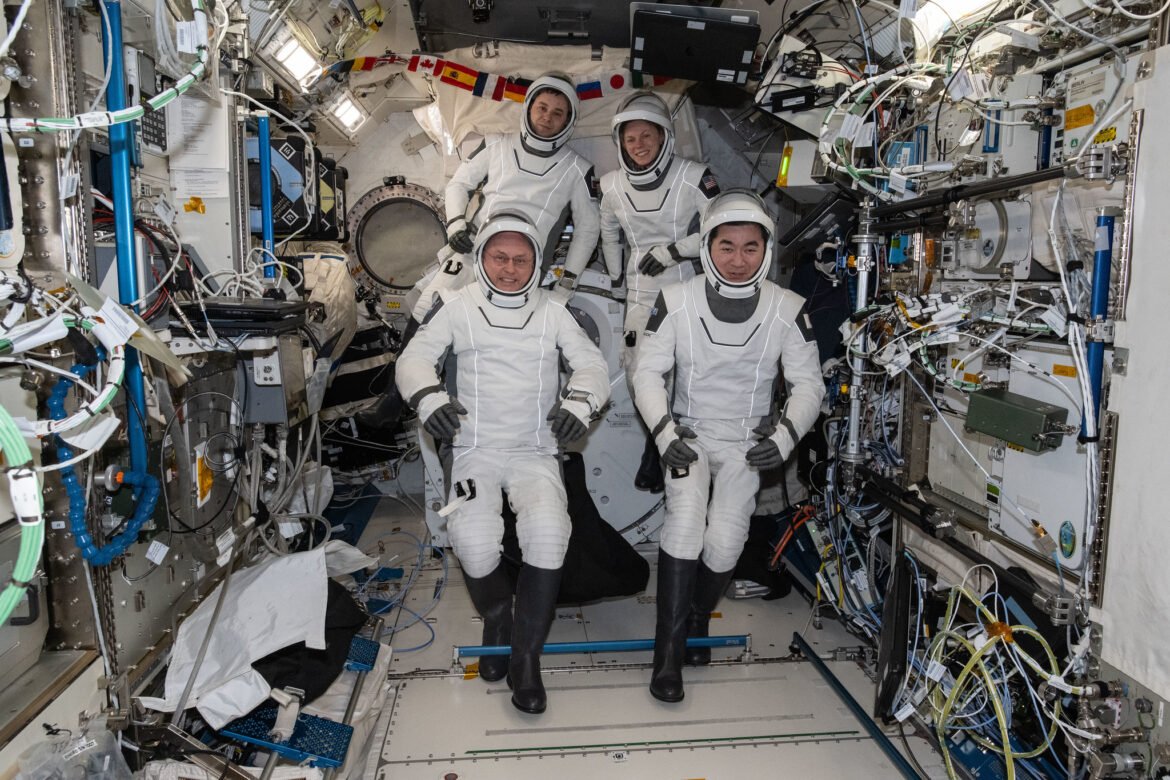 NASA's SpaceX Crew-11 astronauts gather together for a crew portrait wearing their Dragon pressure suits during a suit verification check inside the International Space Station's Kibo laboratory module. Clockwise from bottom left are, NASA astronaut Mike Fincke, Roscosmos cosmonaut Oleg Platonov, NASA astronaut Zena Cardman, and JAXA (Japan Aerospace Exploration Agency) astronaut Kimiya Yui.