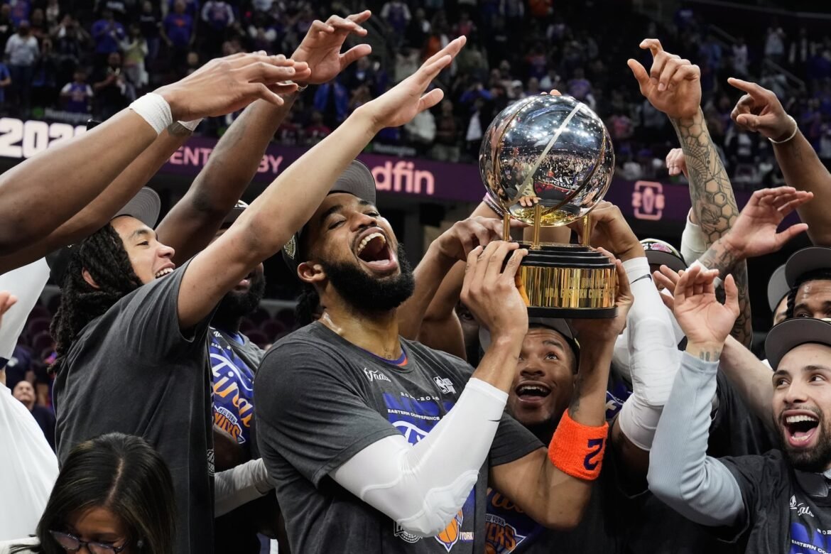 New York Knicks center Karl-Anthony Towns, center, and teammates celebrate after winning Game 4 in the Eastern Conference finals NBA basketball playoffs series against the Cleveland Cavaliers in Cleveland, Monday, May 25, 2026. (AP Photo/Sue Ogrocki)