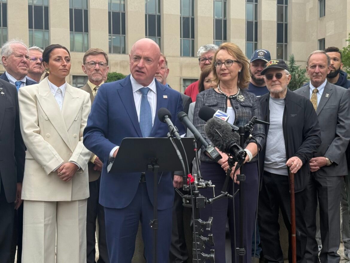 Arizona Democratic Sen. Mark Kelly speaks outside the&nbsp;E. Barrett Prettyman U.S. Courthouse and William B. Bryant Annex in Washington, D.C., on Thursday, May 7, 2026, following oral arguments in federal appeals court in his case against the Defense Department. Former Arizona Rep. Gabby Giffords, who is married to Kelly, and supporters surround Kelly. (Photo by Jennifer Shutt/States Newsroom)