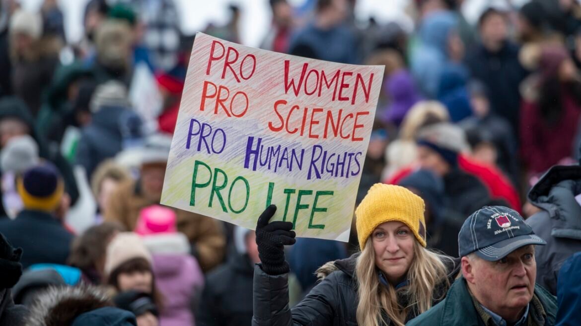 A protester holds a sign that says "Pro women pro science pro human rights pro life"