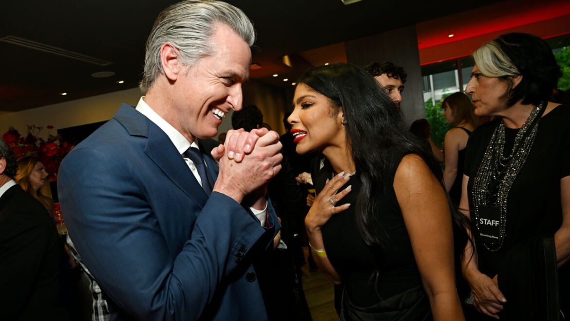 Gavin Newsom clasps his hands with glee while talking to Olivia Igbokewe Curry.
