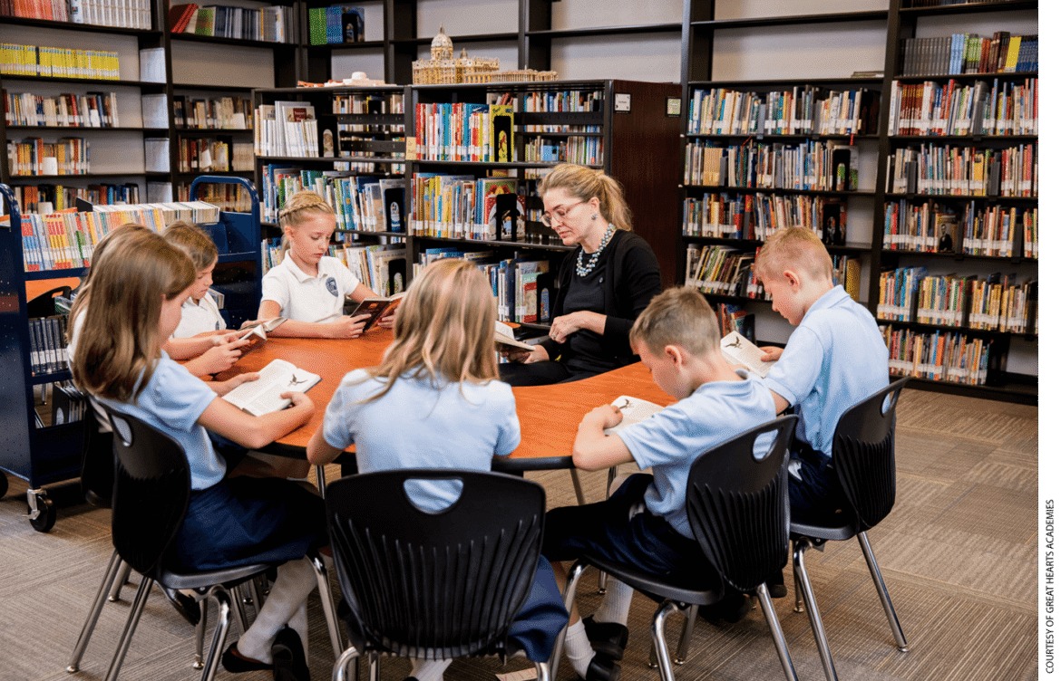 A teacher leads student reading in a classroom