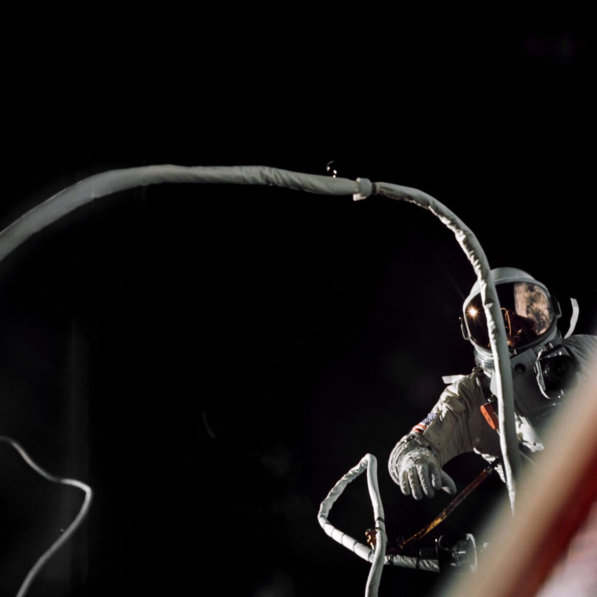 Gemini IX-A astronaut Gene Cernan is backdropped by the blackness of space during America’s second spacewalk on June 5, 1966. His umbilical drifts across the foreground, partially obscuring the view of the astronaut.