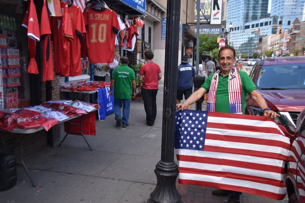 Fayez Ghabour, 69, peddled soccer jerseys, scarves and flags outside his shop, E & F Food Market on Bergen Avenue in Jersey City, as the World Cup arrived in New Jersey on Saturday.