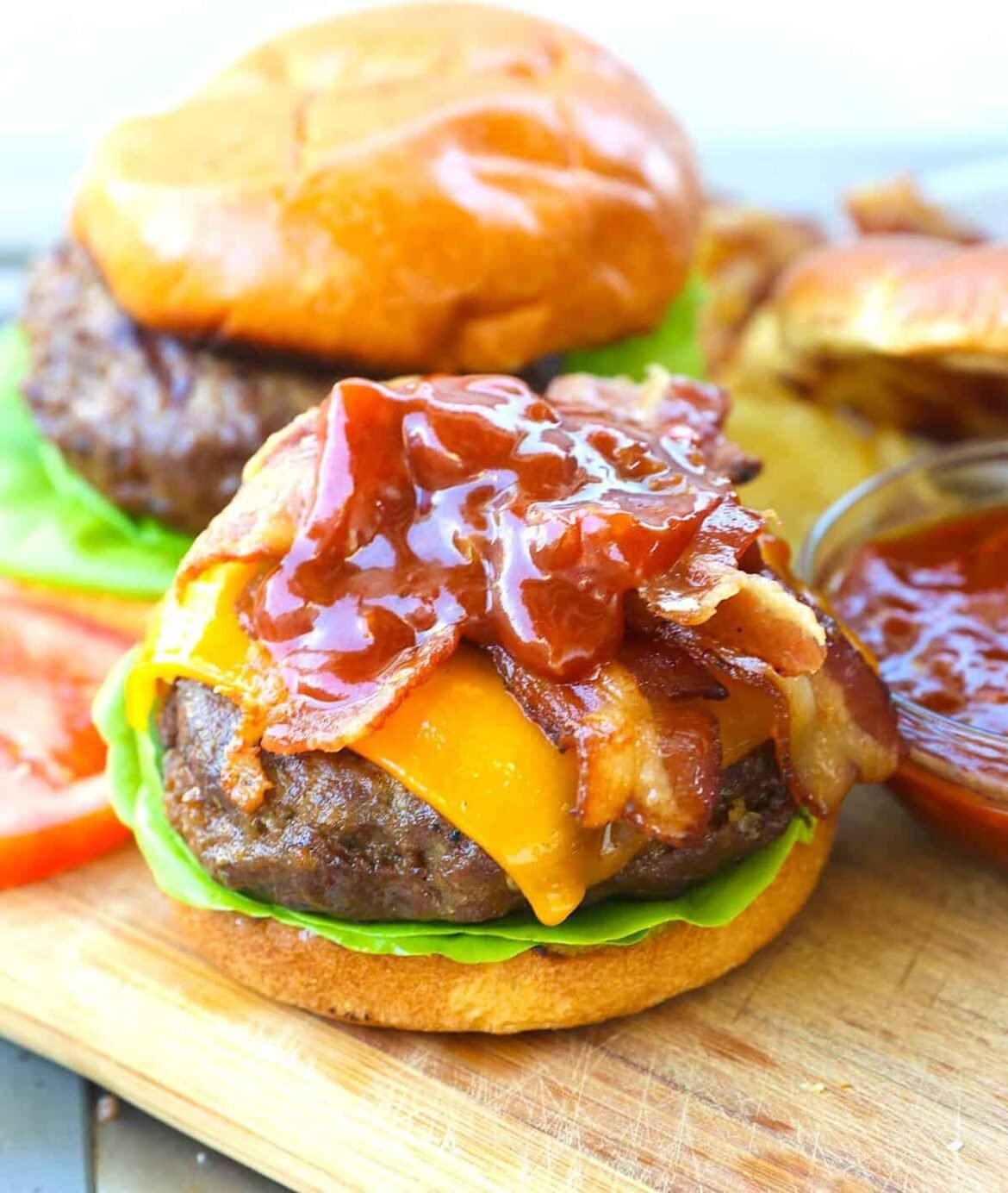 Topping a grilled burger with BBQ sauce and bacon for the best backyard burger you'll enjoy.