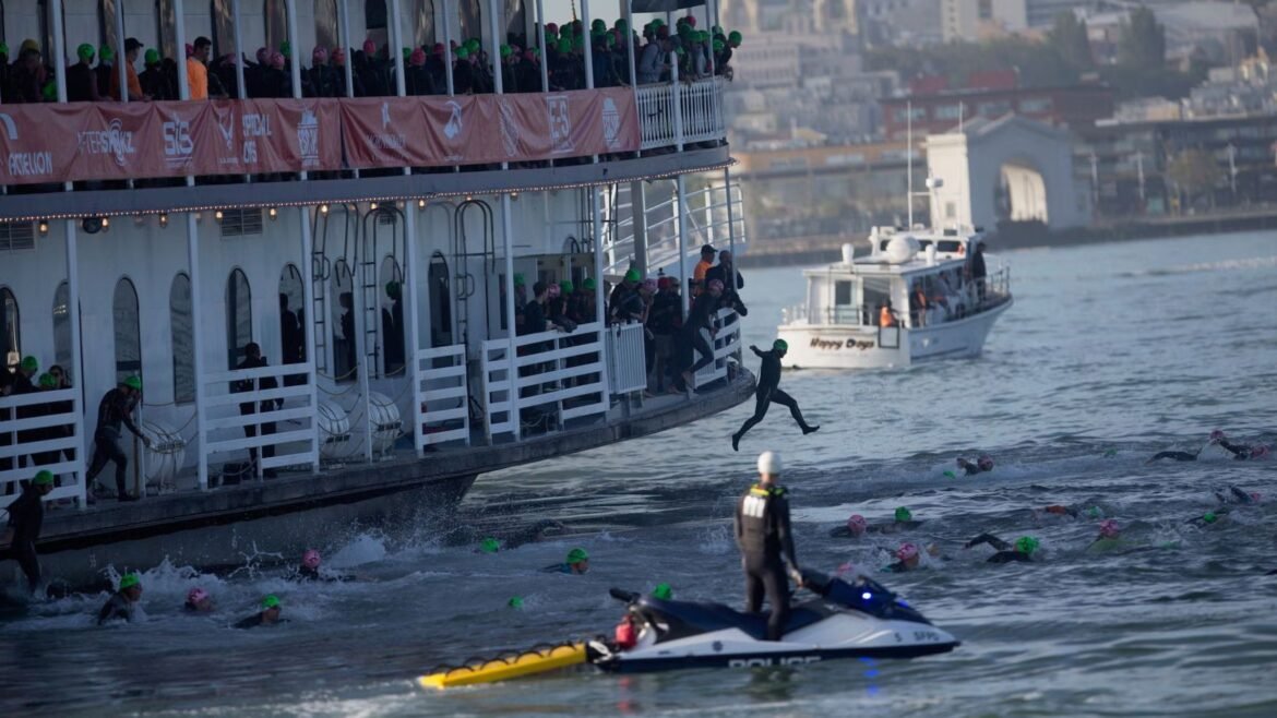 Athletes jump off the San Francisco Belle to begin the swim start of the Escape From Alcatraz Triathlon.