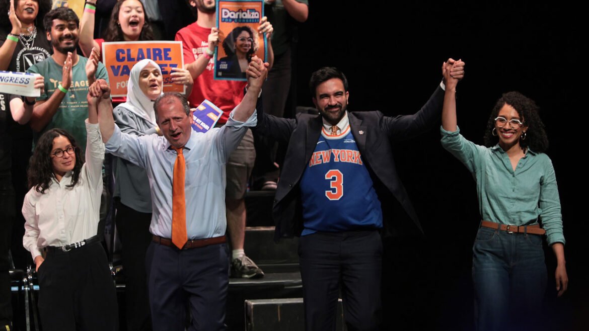 Claire Valdez, Brad Lander, Mayor Zohran Mamdani, and Darializa Avila Chevalier raise their hands on stage during a rally.