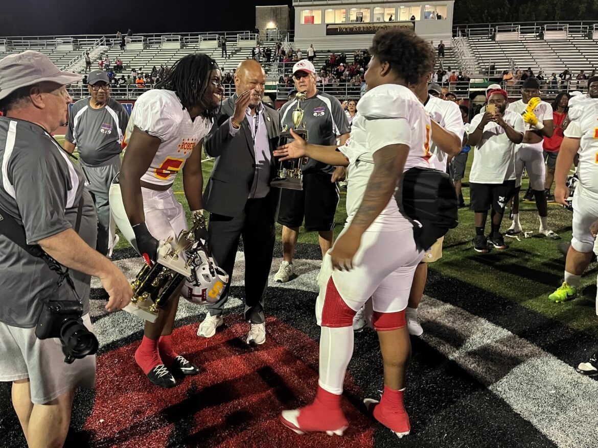 Hoboken's Isaiah Blanks is congratulated by New Jersey State Senator Benjie Wimberly and teammate Daysun Looby of Hillside after being selected as the East Offensive MVP at the 2026 Paul Robeson East-West All-Star Classic