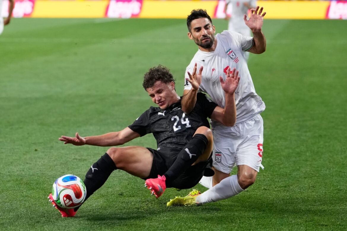 New Zealand's Callan Elliot (24) challenges for the ball with Iran's Milad Mohammadi (5) during the World Cup Group G soccer match between Iran and New Zealand in Inglewood, Calif., near Los Angeles, Monday, June 15, 2026. (AP Photo/Mark J. Terrill)