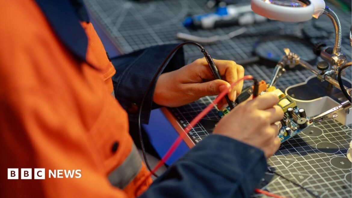 A female worker testing a circuit board in a workshop