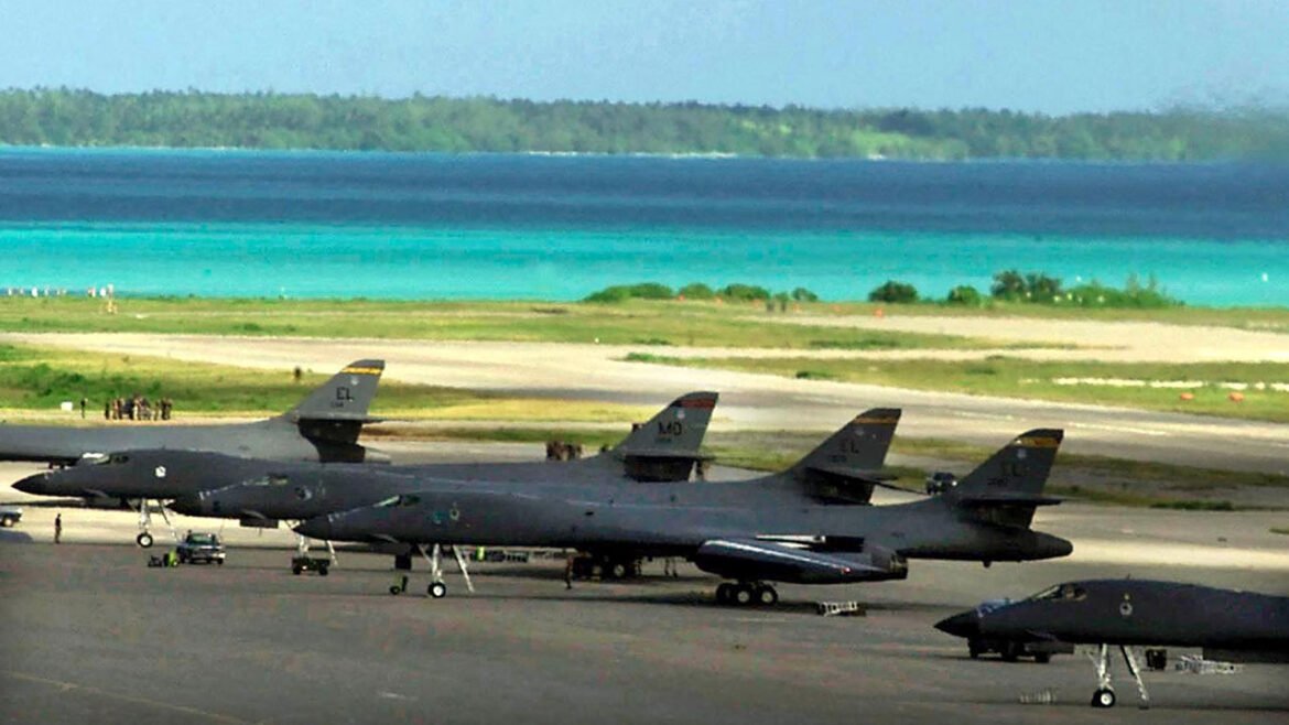 American fighter planes sit on a runway at Diego Garcia base with beautiful blue island waters in background.