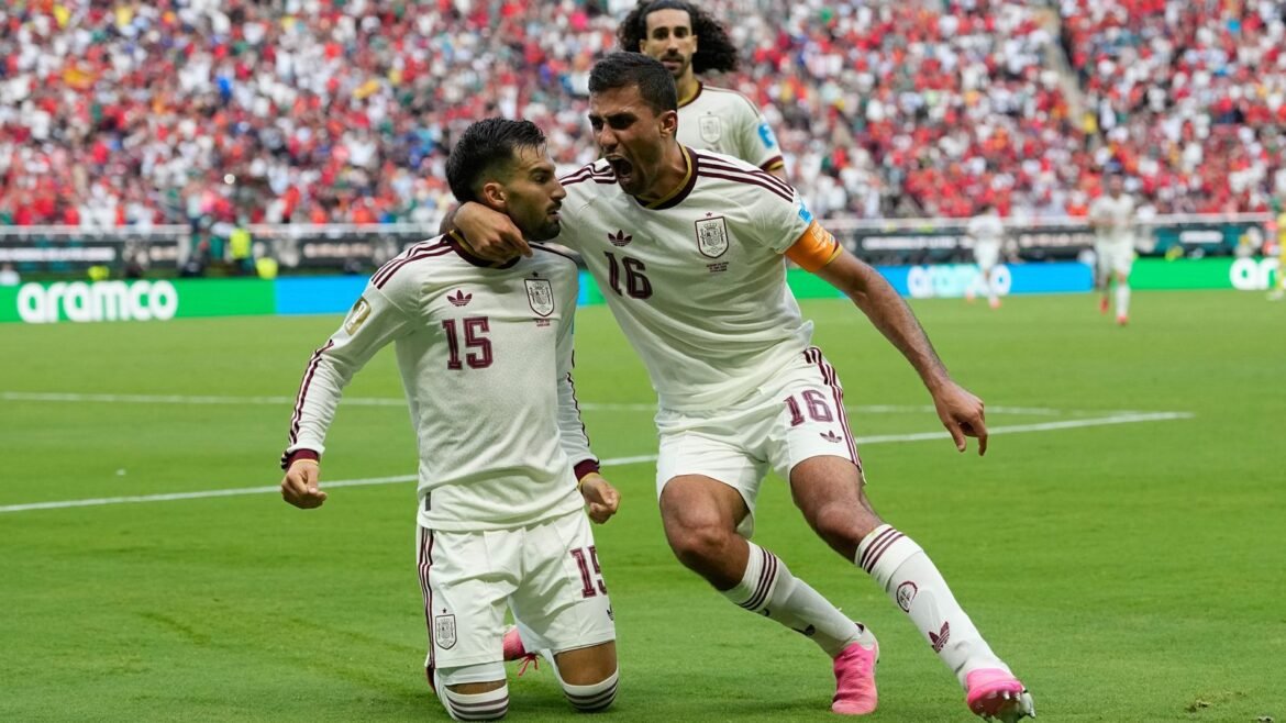 Spain's Alex Baena, left, is congratulated after scoring his side's opening goal against Uruguay by Rodri