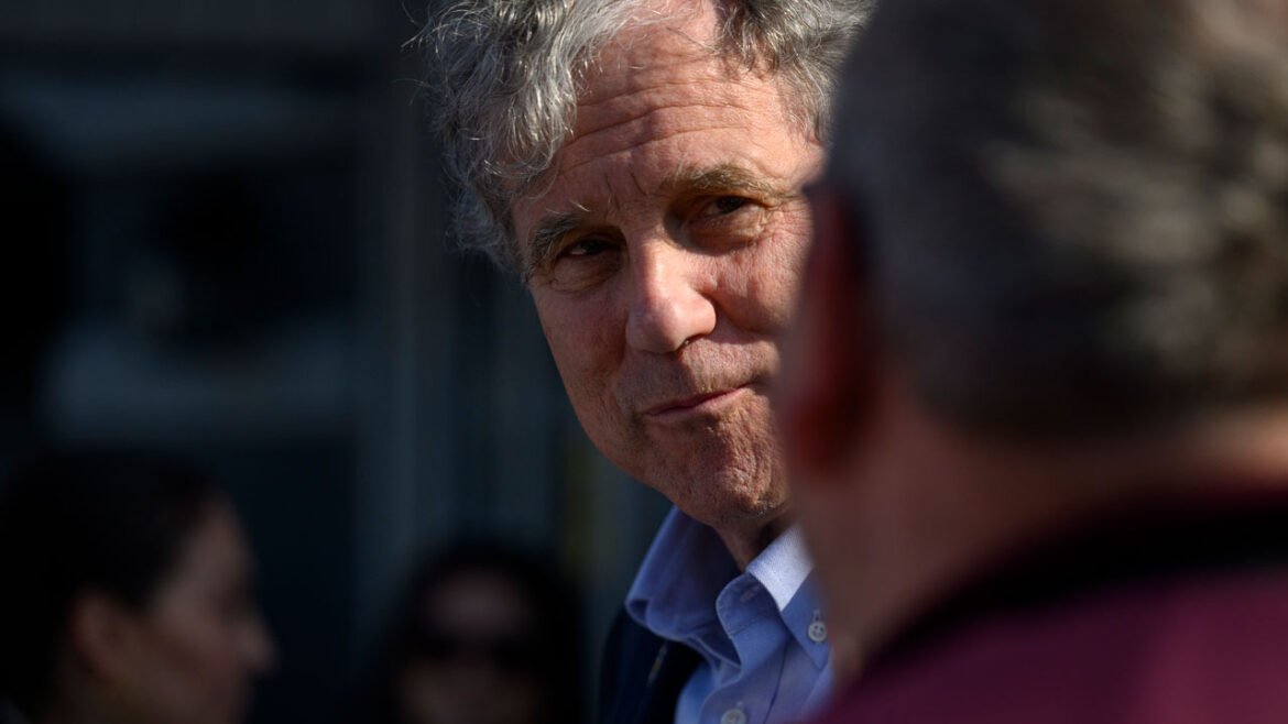 Sherrod Brown, an Ohio Democrat, looks on at another person.