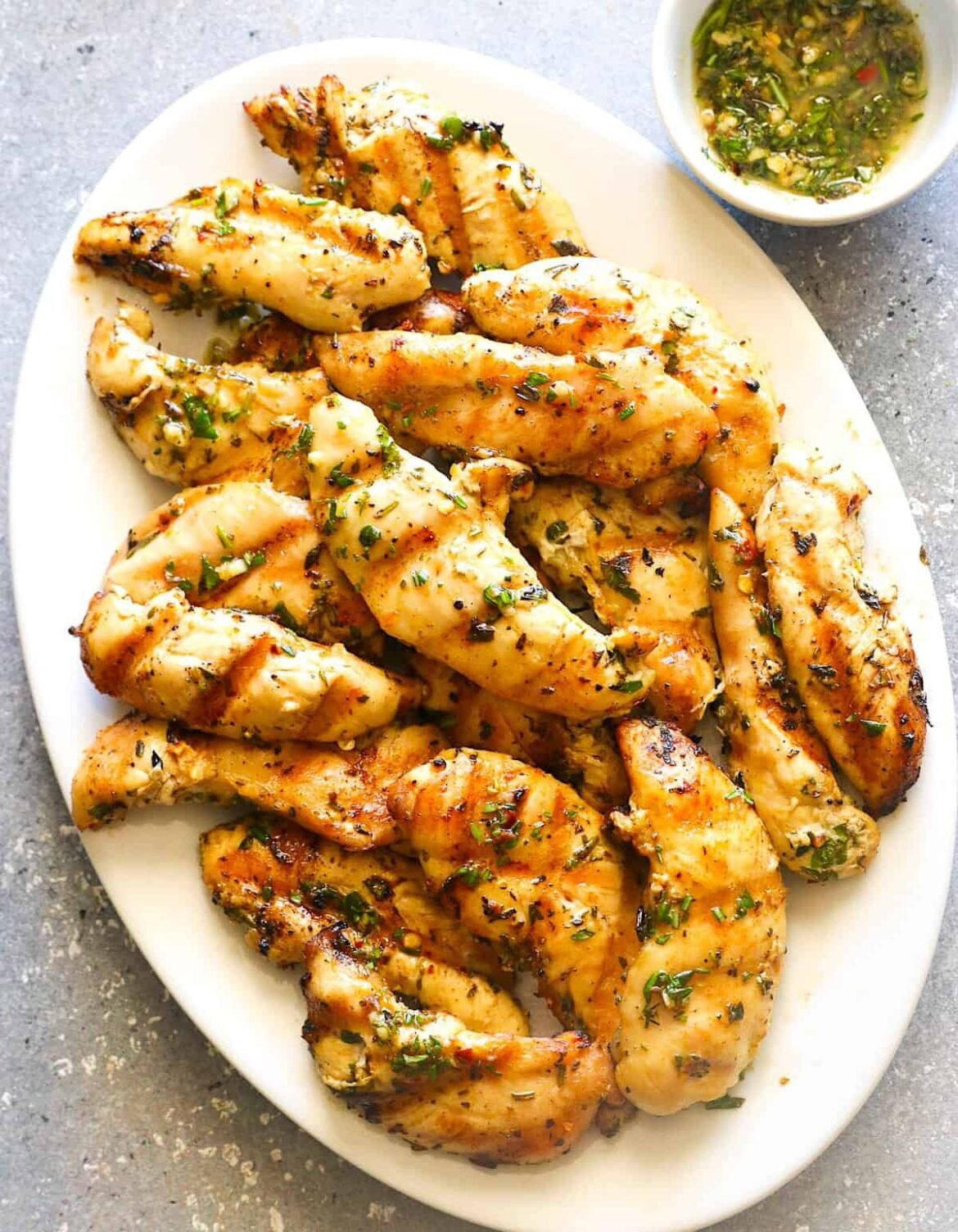 Serving up a platter filled with juicy, smoky, and freshly grilled chicken tenders.