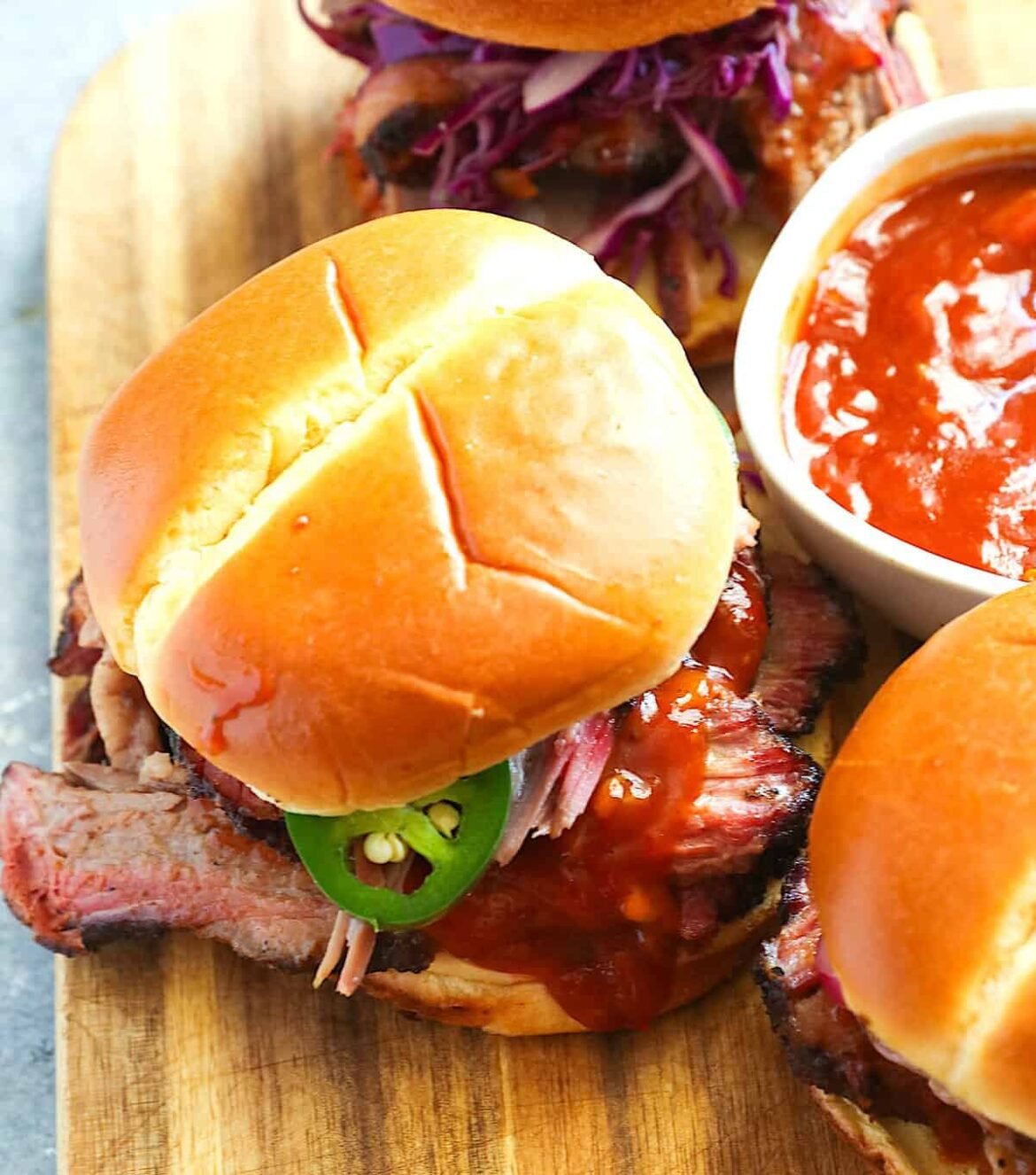 Assembling an amazing leftover beef brisket sandwich with BBQ sauce.