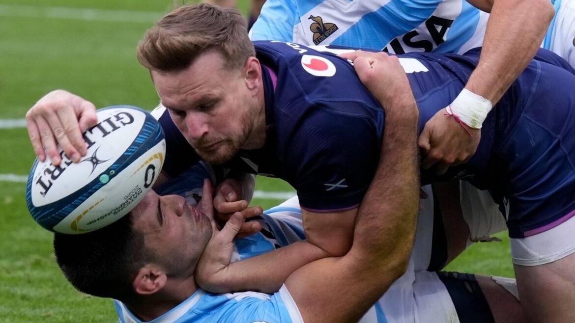 Scotland's Rory Hutchinson, center, scores a try as Argentina's Tomas Albornoz, top, tackles him during a Nations Championship rugby match