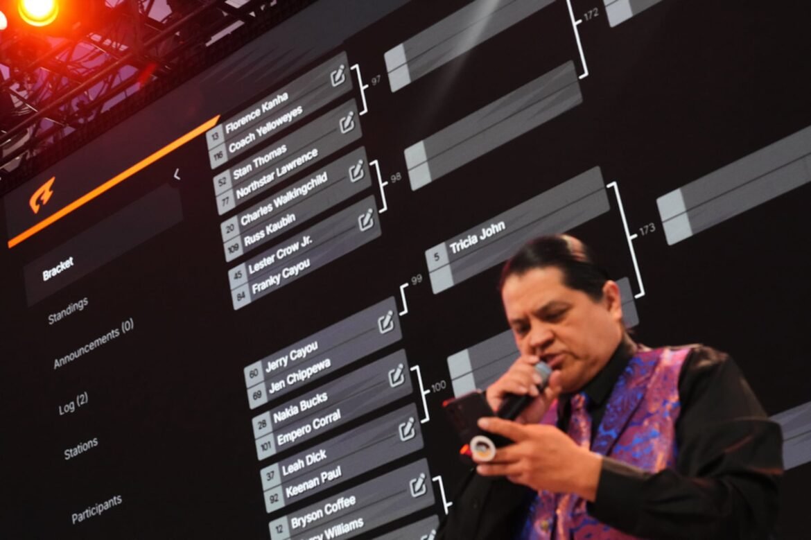 A large bracket is shown behind emcee Andre Picard Jr., of the Nez Perce Tribe, during a Stick-Games Tournament hosted by the Puyallup Tribe in partnership with World Cup host city Seattle, Saturday, June 27, 2026, in Tacoma, Wash. (AP Photo/Lindsey Wasson)