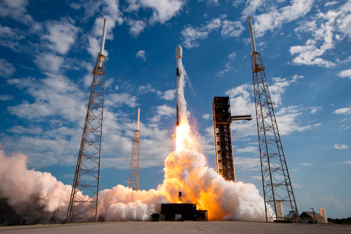 a rocket lifts off against a partly cloudy sky