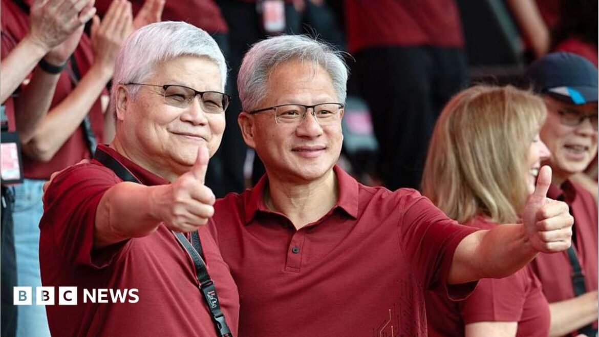 Jensen Huang, chief executive officer of Nvidia (right), poses for photographs with TSMC boss CC Wei smiling with their thumbs up. Both men are dressed in red polo t-shirts  