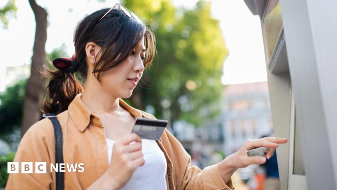 A woman in a leather jacket paying for her drinks by tapping a card machine with her phone