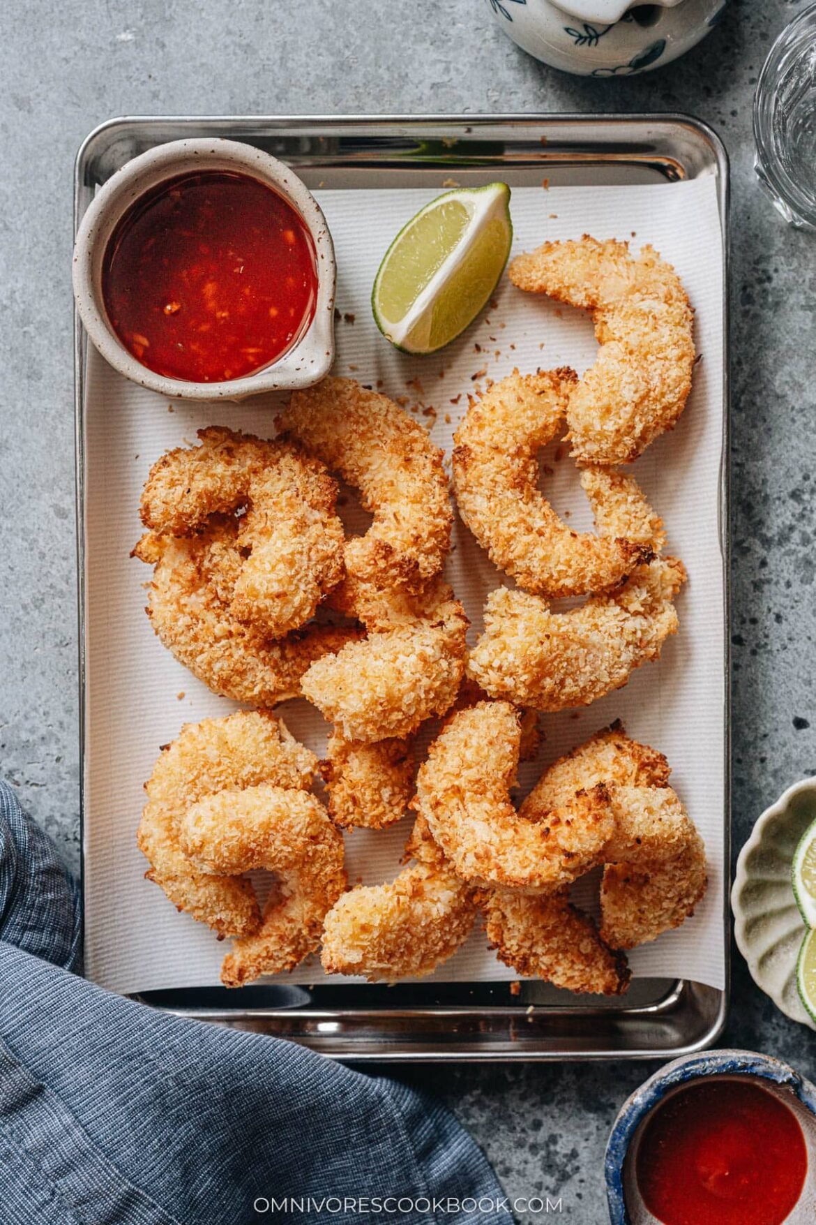 air fryer coconut shrimp plated with lime and sauce