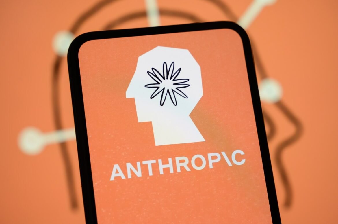 The Anthropic logo is displayed on the screen of a smartphone with the company's branding in the background.