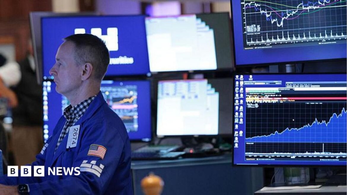 A stock market trader monitors screens on the stock market