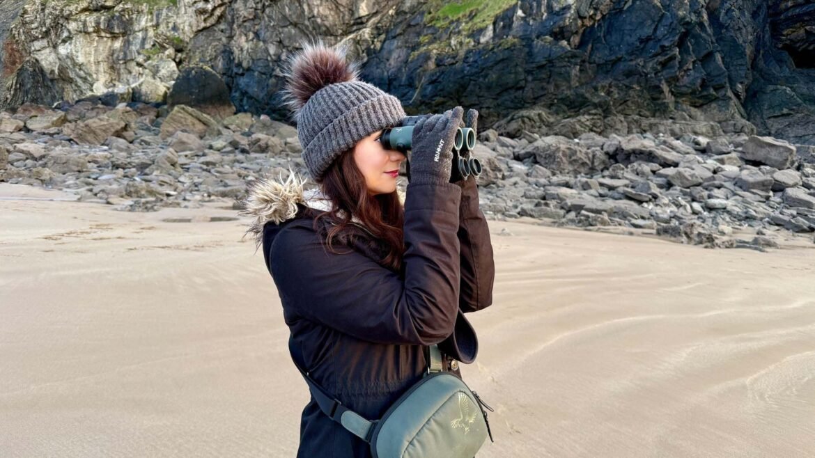 A woman using the Swarovski NL Pure 8x32 at the beach