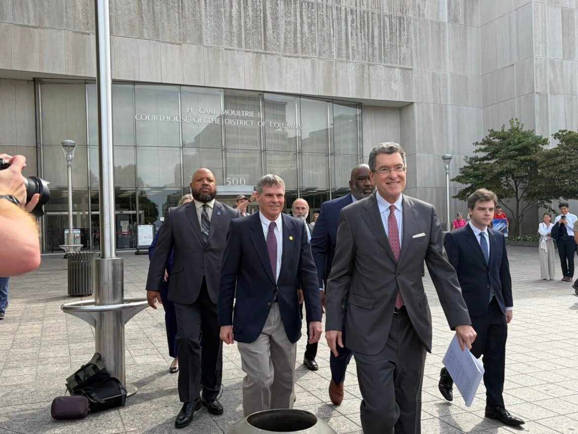 Olympian David Hearn, center left, walks out of District of Columbia Superior Court with his attorneys after a hearing on Sept. 4, 2026. (Photo by Ariana Figueora/States Newsroom)