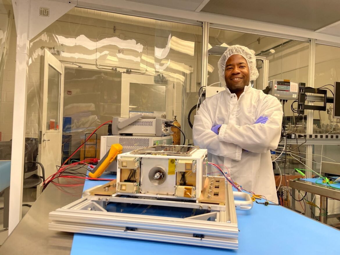 An Album of photos showing NASA engineers and technicians in white protective clean room suits working on a small, rectangular spacecraft module. They are shown inspecting the hardware on a laboratory workbench, wrapping it in silver foil, and loading it into a large, metallic vacuum chamber at NASA's Marshall Space Flight Center