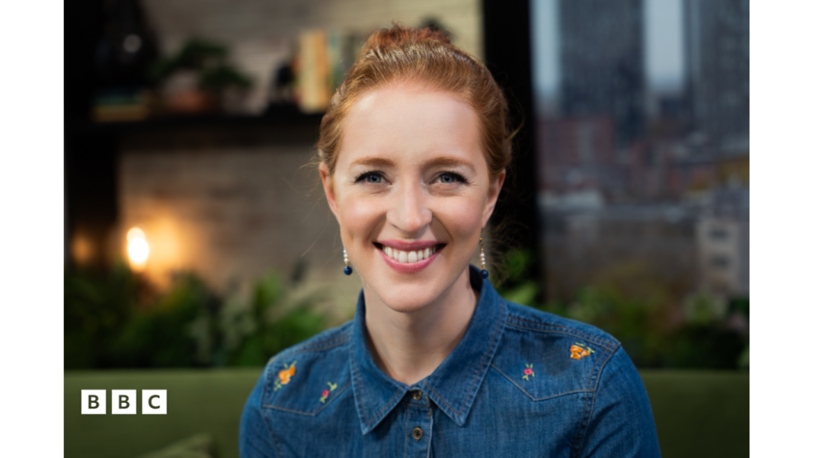 Finance expert Iona Bain sitting on the Morning Live green sofa, in the Morning Live studio, wearing a blue denim jacket, smiling