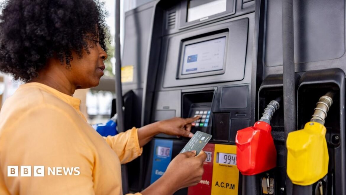 A woman pays for fuel at a gas station with her bank card