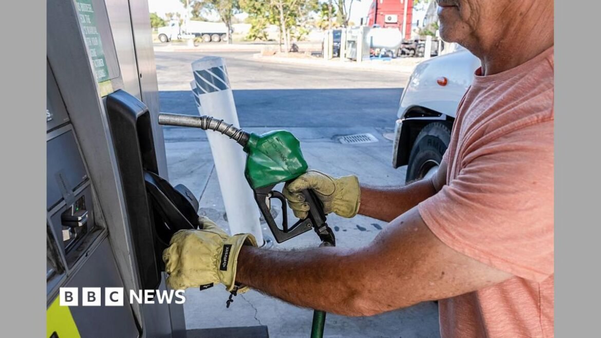 A driver returns a fuel nozzle after refueling a tractor trailer with diesel fuel at a Chevron truck stop in Tracy, California. 