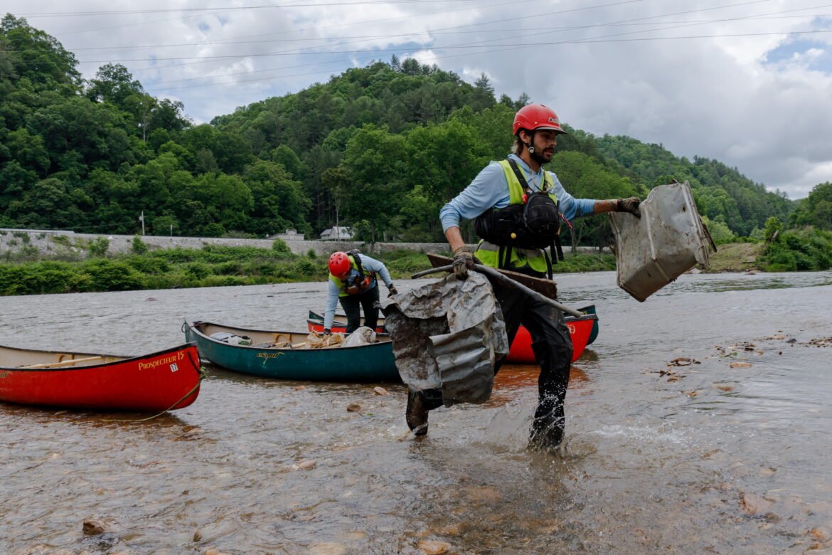 Hayden Cheek cleans debris out of the North Toe River in Western North Carolina nearly two years after Hurricane Helene hit the area.