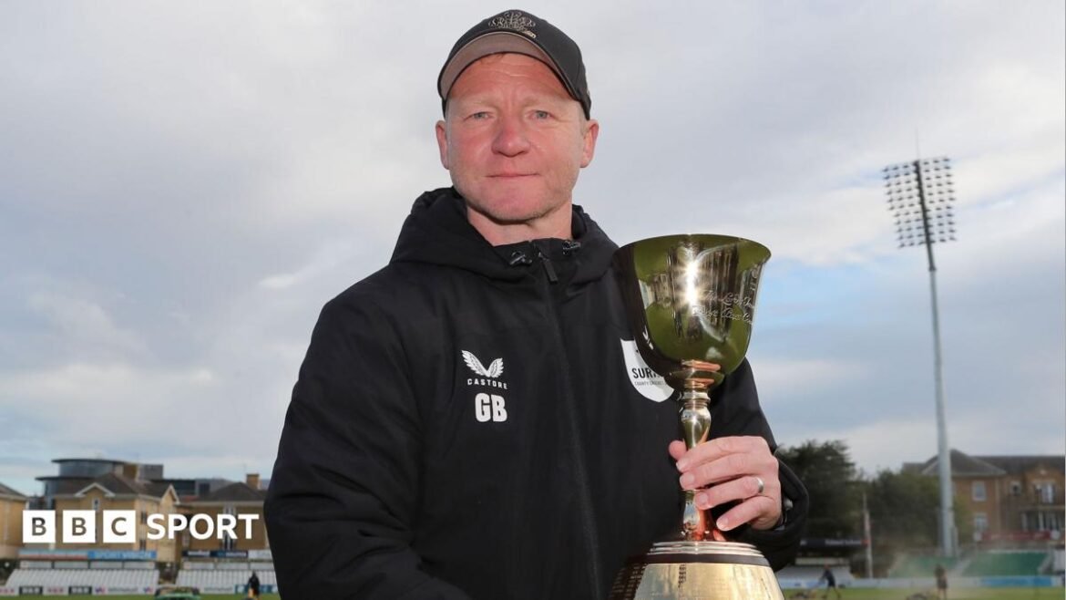 Gareth Batty in Surrey hoodie holding the County Championship trophy